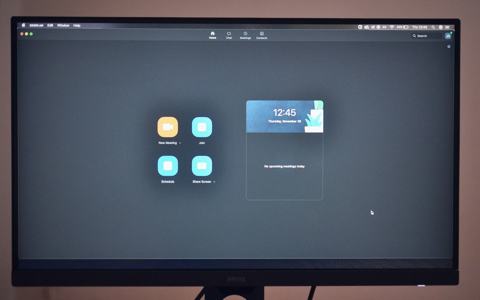A BenQ monitor displaying the Zoom app home screen with meeting options